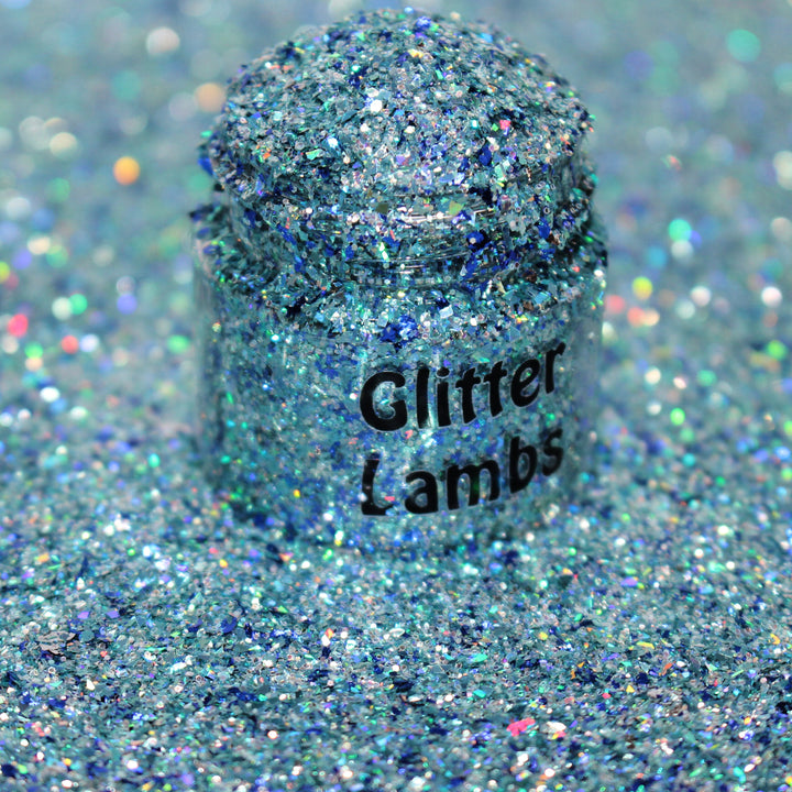 Icy blue shard glitter called “I Just Want To Watch Christmas Movies” in a 5 gram bag, part of the Christmas Is Here glitter collection, perfect for nails, resin art, tumblers, and holiday crafts.