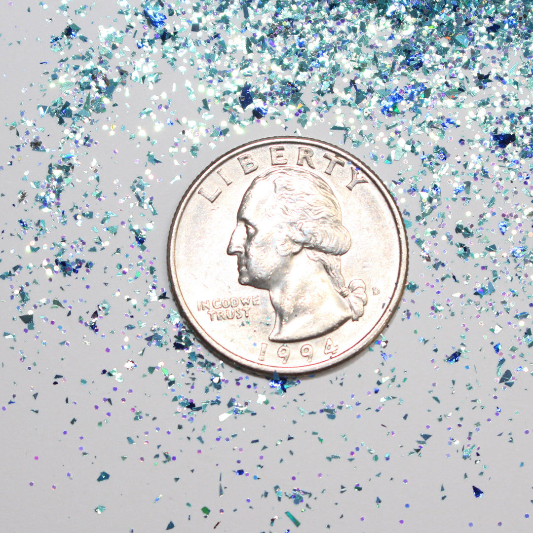 Icy blue shard glitter called “I Just Want To Watch Christmas Movies” in a 5 gram bag, part of the Christmas Is Here glitter collection, perfect for nails, resin art, tumblers, and holiday crafts.