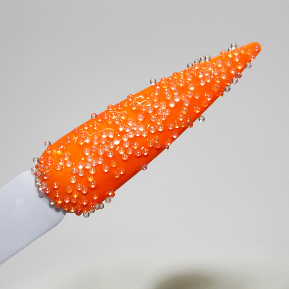 A Whisker Of A Cat Caviar Beads (0.6-0.8mm) by GlitterLambs.com Ivory Colored. Swatched on nail over orange nail polish in Salon Perfect "Traffic Cone".